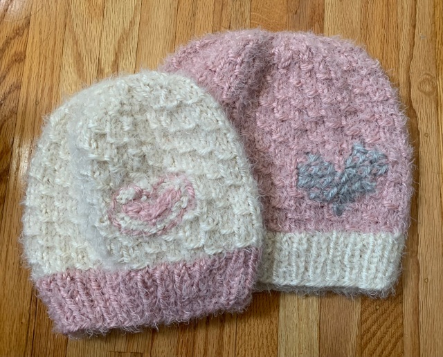 Adult and child size hats shown with hearts on them.